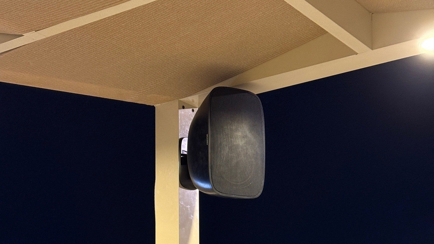 Outdoor speaker on a wooden deck with a dark sky background